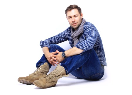 Flirtatious man sitting on the floorの写真素材