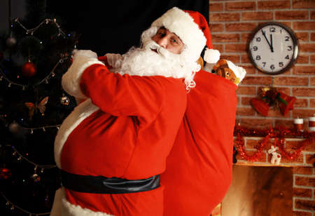 Santa Claus holding carrying sack with gifts for kids