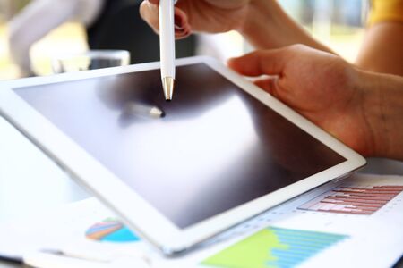 Business person analyzing financial statistics displayed on tablet screen