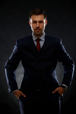 Handsome young business man standing on blackの写真素材