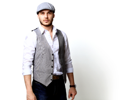 Happy young man. Portrait of handsome young man smiling while standing against white backgroundの写真素材