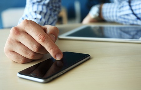 Young businessman working with modern devices, digital tablet computer and mobile phone. Analyze...