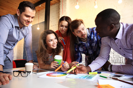 Portrait of happy young people in a meeting looking at camera and smiling. Young designers working together on a creative project.の写真素材