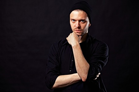 Portrait of young handsome man in t-shirt on black