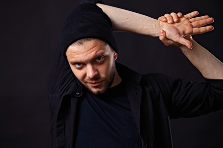 Portrait of young handsome man in t-shirt on blackの写真素材