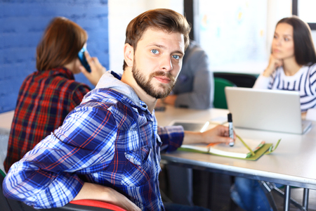 Businessman with colleagues in the background in officeの写真素材