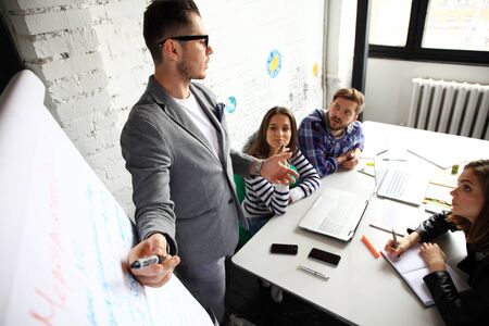 Cheerful businessman discussing a new business project with the members of his teamの写真素材