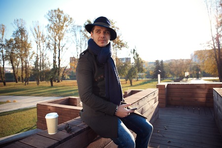 Trendy handsome young man in autumn fashion standing in urban environmentの写真素材