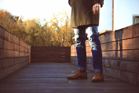 Trendy handsome young man in autumn fashion standing in urban environmentの写真素材