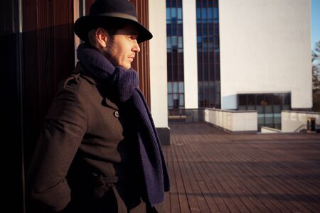Trendy handsome young man in autumn fashion standing in urban environmentの写真素材
