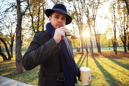 Trendy handsome young man in autumn fashion standing in urban environment.の写真素材