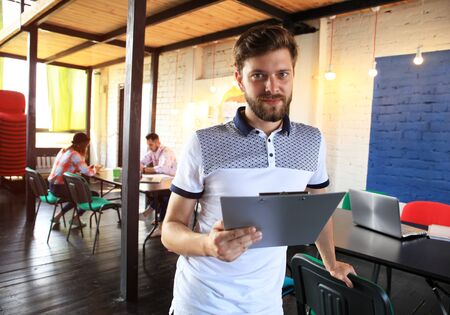 Businessman with colleagues in background in officeの写真素材