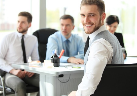 Happy smart business man with team mates discussing in the background