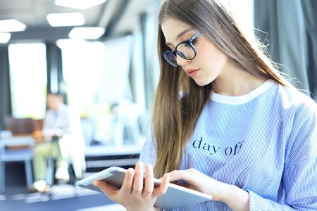 Attractive businesswoman working on a digital tablet in the office.