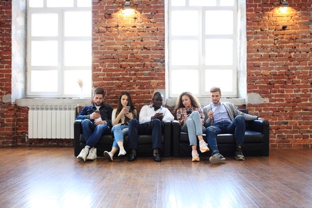 Diverse Group of People Community Togetherness Technology Sitting Concept.の写真素材