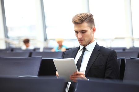 Businessman Using Digital Tablet In Airport Departure Loungeの写真素材