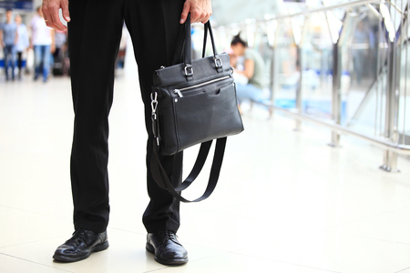 A young handsome businessman student in a suit, comes with a briefcase, at the station, airport. Concept - a new business, traveling the world, communication, contacts, a new deal, success, walk.の写真素材