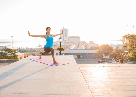 Young woman doing yoga in morning parkの写真素材