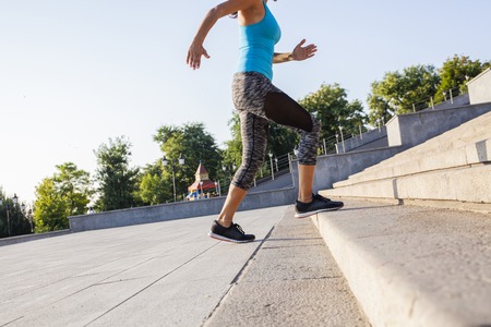 healthy lifestyle sports woman running up on stone stairs sunrise seaside