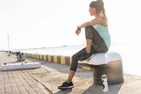 sport and lifestyle concept - woman resting after doing sports outdoorsの写真素材