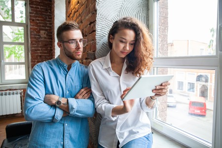 Young business couple working on tablet in modern officeの写真素材