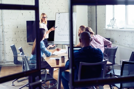 Working hard to win. Businesswoman conducting a business presentation using flipchart while working in the creative office.の写真素材