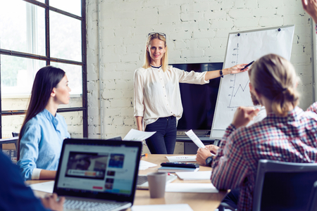 Working hard to win. Businesswoman conducting a business presentation using flipchart while working in the creative office.の写真素材