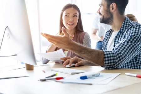 Young modern colleagues in smart casual wear working while spending time in the office.の写真素材
