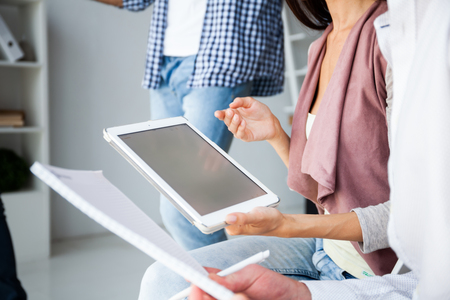 Woman's hands using tablet with financial documentの写真素材