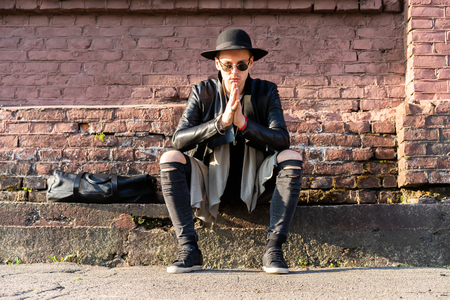 Young man posing with a trendy outfit against a urban background.の写真素材
