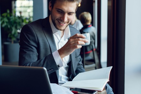 Businessman doing his work and having coffee in cafeの写真素材