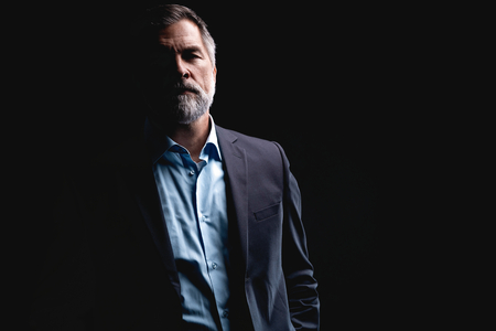 Handsome mature business man isolated on black backgroundの写真素材
