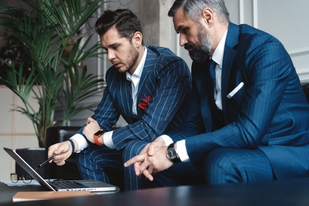 Business executives discussing work, developing strategy for online business, explaining sharing ideas, preparing presentation, having brainstorming session at officeの写真素材