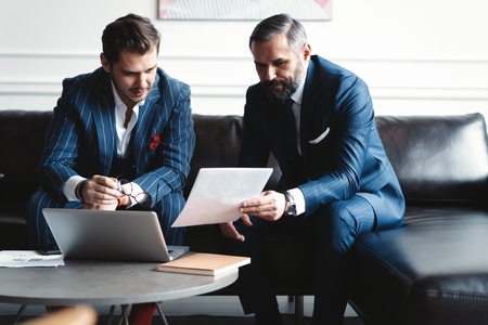 Business executives discussing work, developing strategy for online business, explaining sharing ideas, preparing presentation, having brainstorming session at officeの写真素材