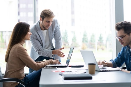 Sharing opinions. Group of young modern people in smart casual wear discussing business while...