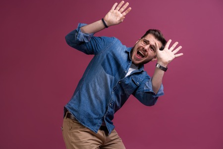 Im afraid. Fright. Scared man. Business man standing isolated on trendy pink studio background. Human emotions, facial expression concept.の写真素材