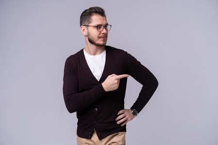 Man presenting something over isolated gray background.の写真素材