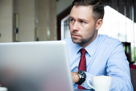 Businessman having coffee and doing his work in cafe.の写真素材