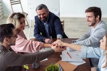Business partners hands on top of each other symbolizing companionship.