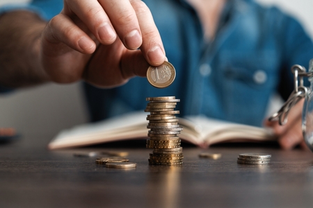 Business man putting a coin on coins stack saving bank and account for his money all in finance accounting conceptの写真素材