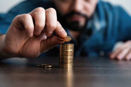 Business man putting a coin on coins stack saving bank and account for his money all in finance...