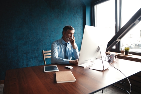 Mature Businessman Working On Computer In Officeの写真素材