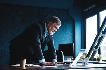 Elegant businessman analyzing data in officeの写真素材