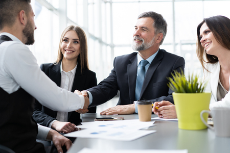 Business people shaking hands while working in the creative officeの写真素材