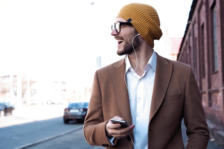 Man in the street listening music from his phone.の写真素材