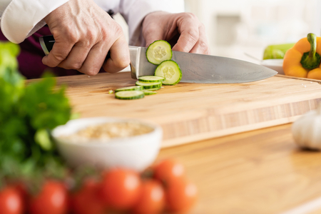 Chef cutting fresh and delicious vegetables for cooking.の写真素材