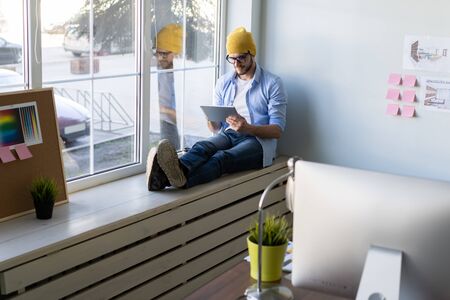 Man using Tablet for Work and Browsing Information, Young creative manager sitting by the window.の写真素材