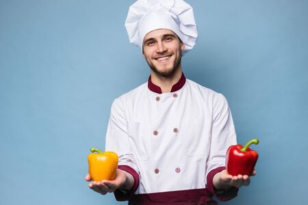 Food service, organic food, healthy diet, cooking and professional culinary concept - chef in white uniform holds vegetables.の写真素材