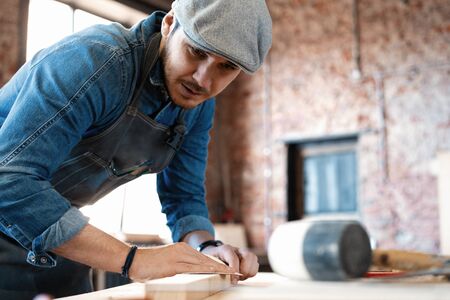 Successful handsome businessman with stylish cap work in carpentryの写真素材