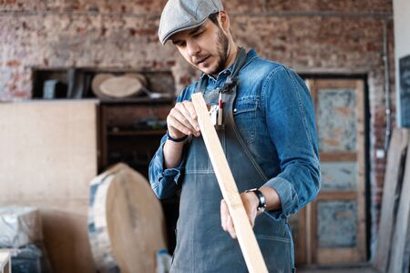 Successful handsome businessman with stylish cap work in carpentry